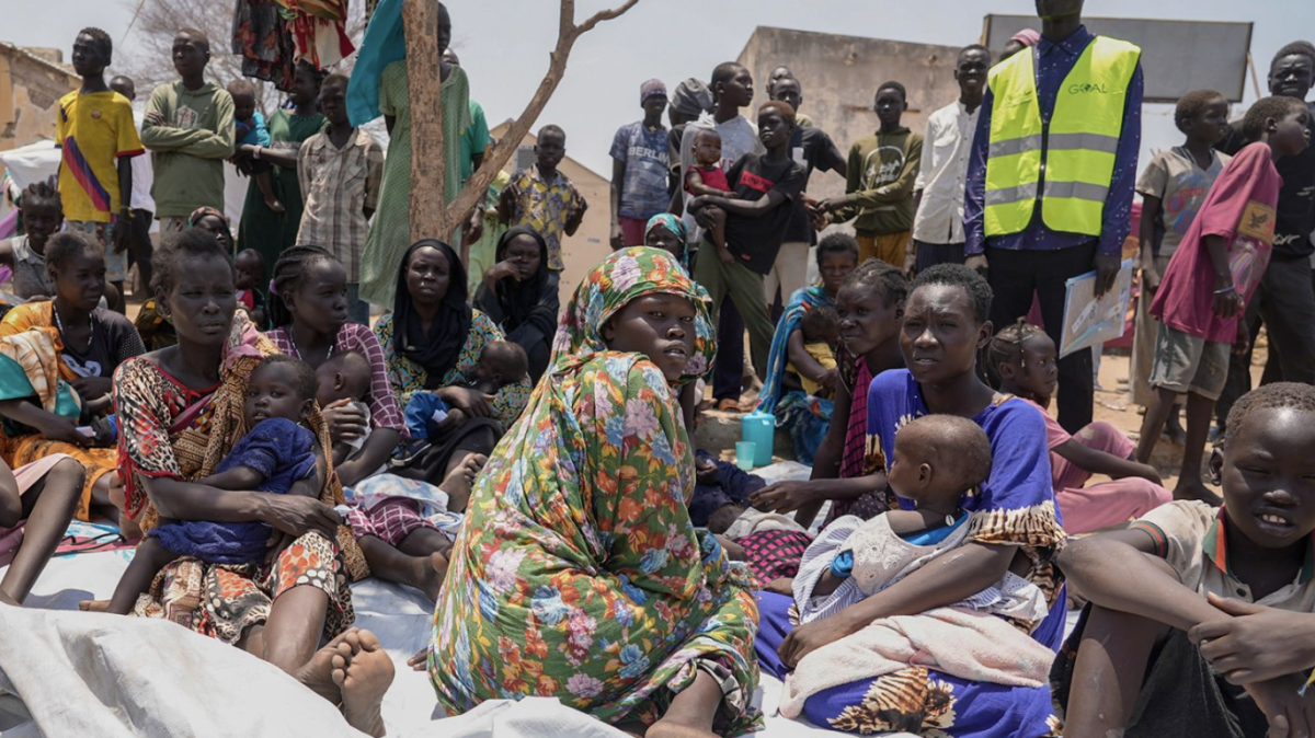 CNN–Sudanese people who have fled and are sitting outside a medical facility