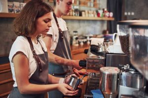 Young female cafe worker indoors. Conception of business and service.